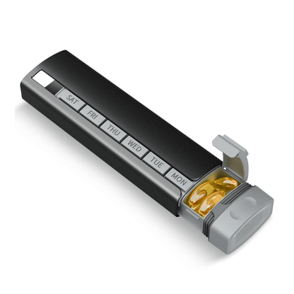 Black pill organizer with open compartment showing yellow pills on a white background