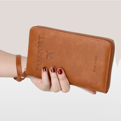 Brown leather passport holder with 'PASSPORT' embossing held by a hand on a light background