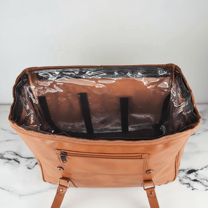 Brown leather bag with a clear plastic liner on a marble surface