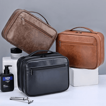Three leather travel bags in brown and black on a gray background with grooming products.