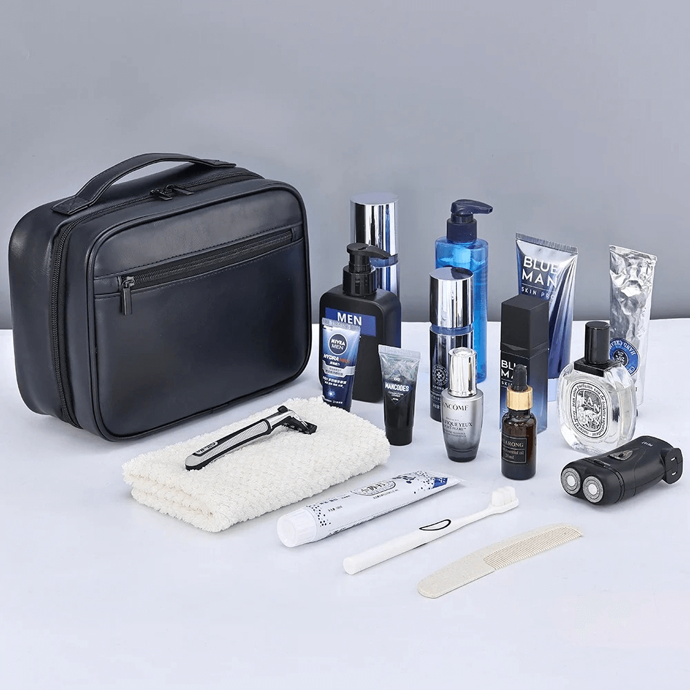 Grooming products including a black travel case, bottles, and personal care items on a light gray background.