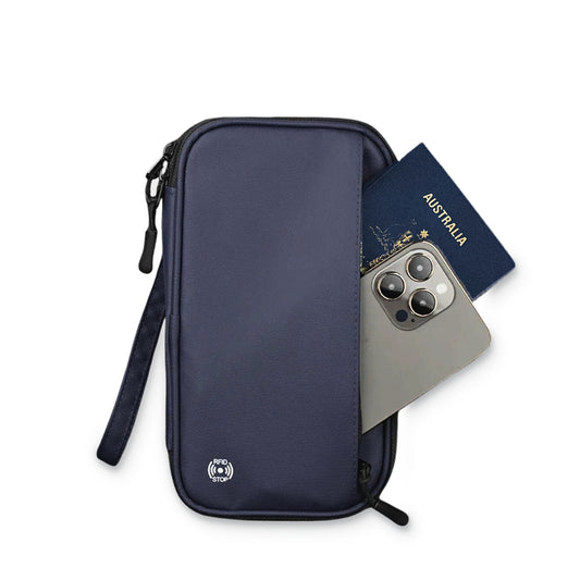 TravelSmart Family Passport Wallet in Navy with a passport and phone in the outer pocket and wrist strap